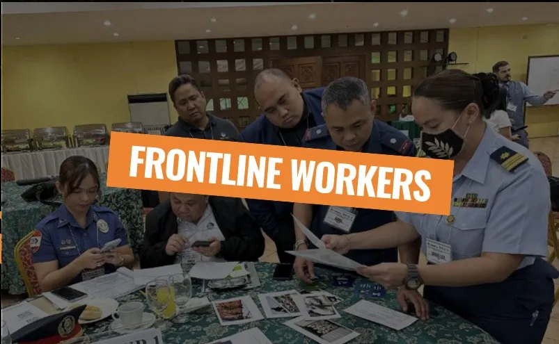 Frontline workers: uniformed officers working through papers at a training table